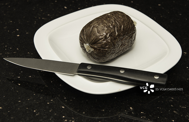 白色盘子上的迷你哈吉斯和刀图片素材