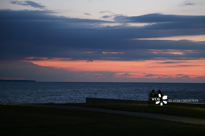 情侣在俄亥俄州莱克伍德公园欣赏日落图片素材