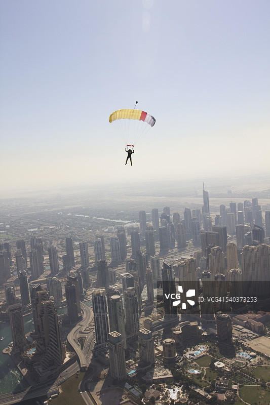 在迪拜城市上空飞行的跳伞者图片素材