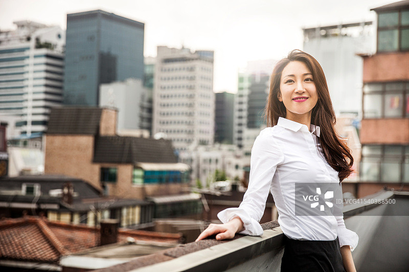 在首尔市中心微笑的年轻商务女性图片素材