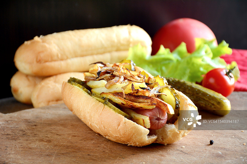 配炸土豆、泡菜和洋葱的热狗图片素材