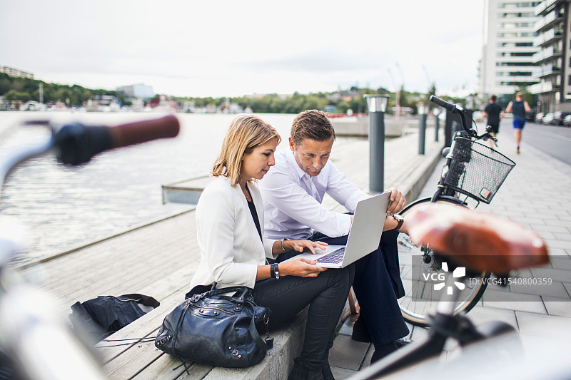 商务人士在晴朗的天空下使用笔记本电脑工作图片素材