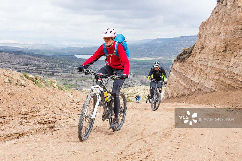 在土耳其卡帕多奇亚山脉骑自行车的女人图片素材