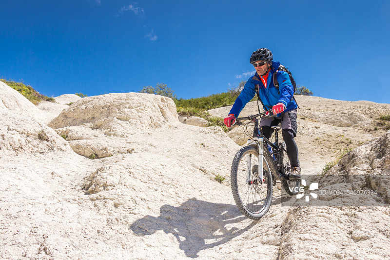 土耳其卡帕多奇亚白色凝灰岩上的单车道山地自行车骑行图片素材