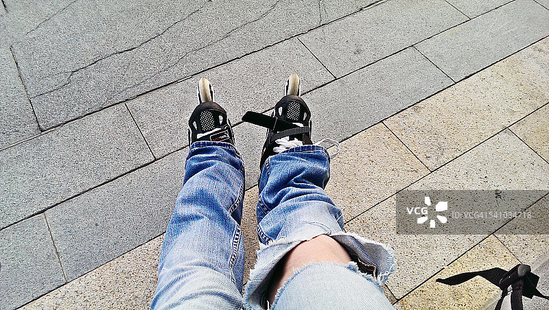穿着牛仔裤和旱冰鞋休息的女人图片素材