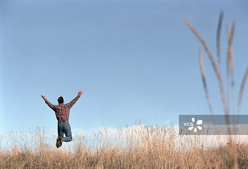 张开双臂跳跃的男人图片素材
