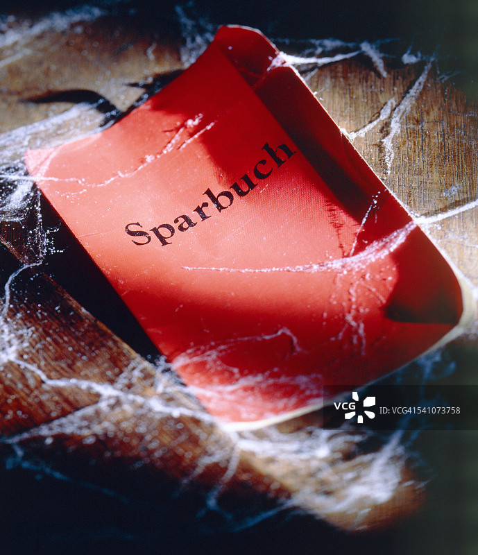 布满蜘蛛网的红色储蓄存折图片素材