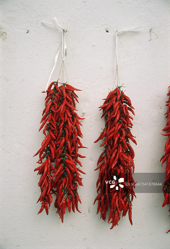 意大利伊斯基亚墙上悬挂的两串辣椒图片素材