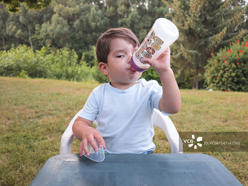 男婴用奶瓶喝奶图片素材