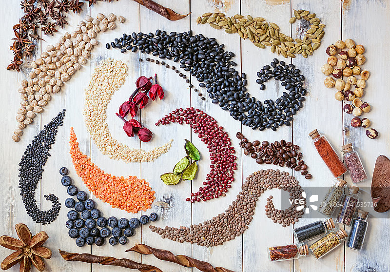 木桌上的豆类、种子和香草漩涡图片素材