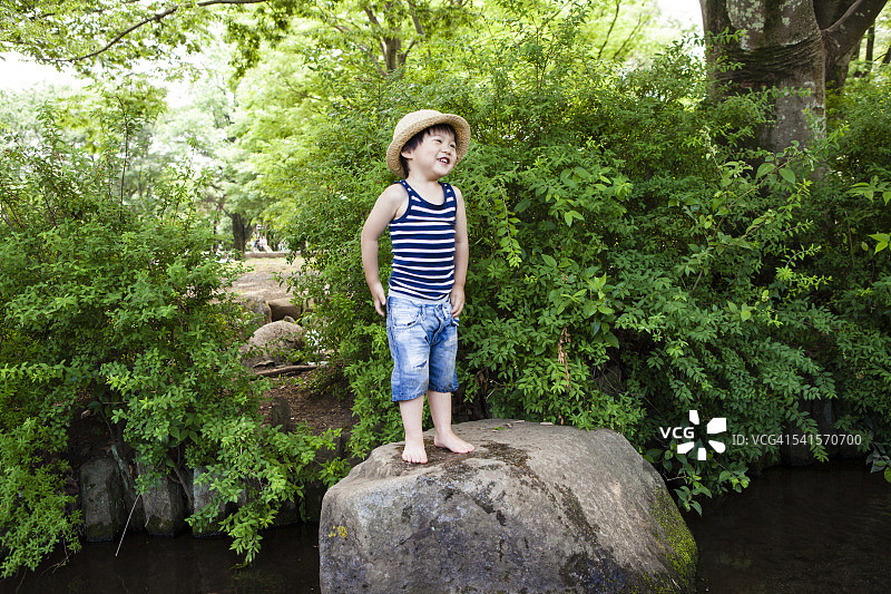 孩子们站在大石头上欢笑图片素材