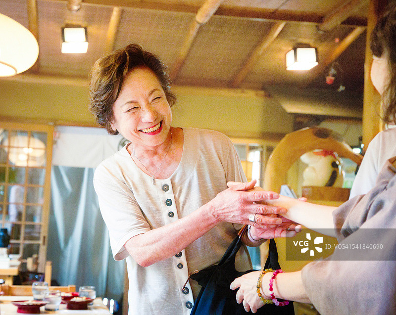 受到朋友欢迎时微笑的年长日本妇女图片素材