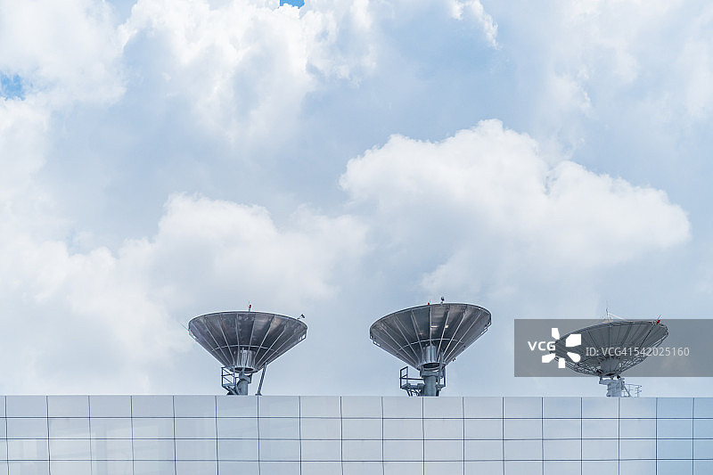 三个无线电卫星和多云背景图片素材