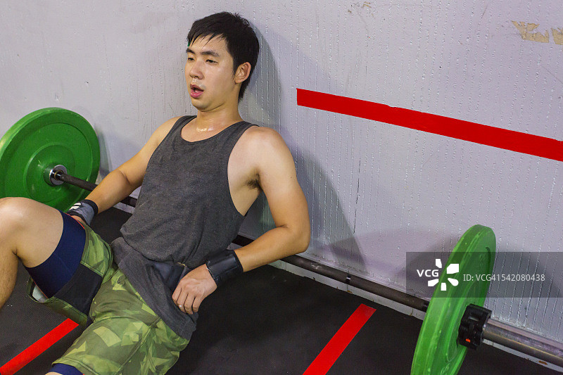 精疲力尽的交叉训练运动员在举重训练后休息图片素材