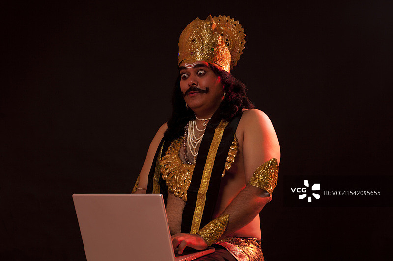 男人打扮成罗波那的样子，在笔记本电脑上工作图片素材