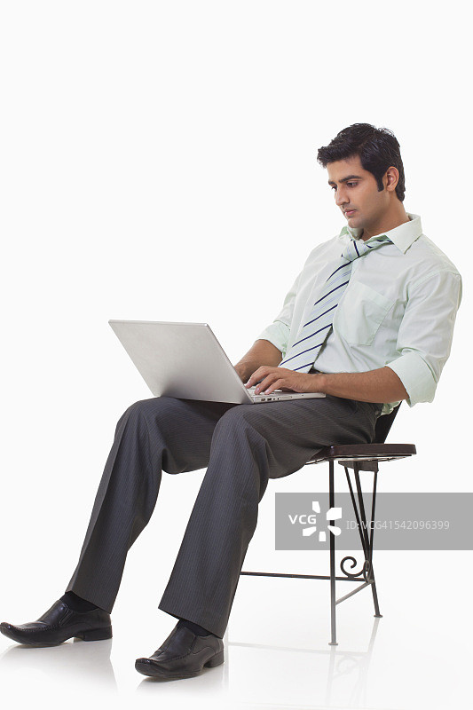 使用笔记本电脑工作的英俊商人图片素材