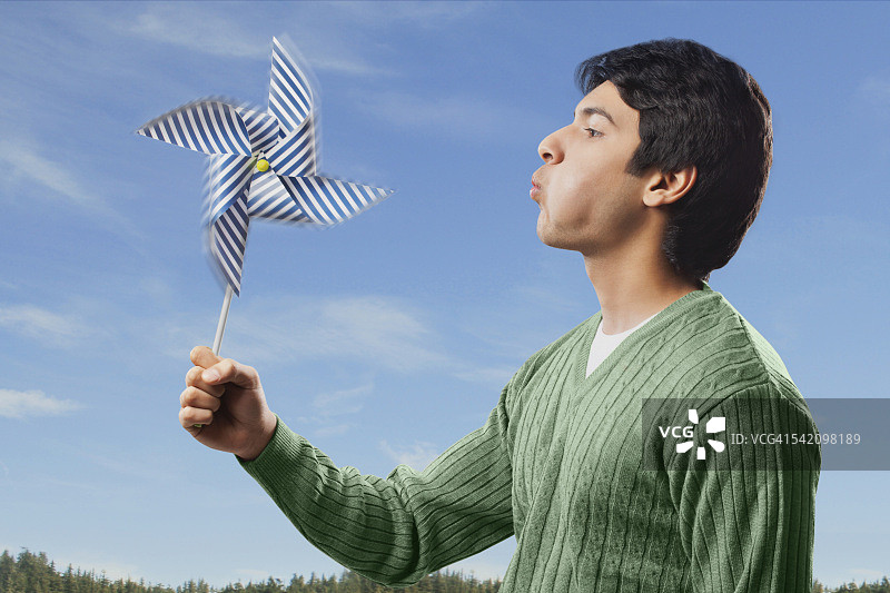 男人吹着风车图片素材
