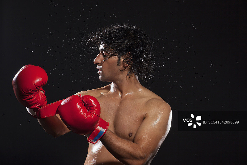 戴着拳击手套甩头发的年轻男人图片素材