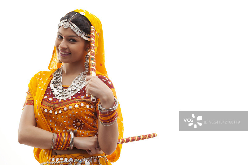 身穿传统服装，手持dandiyas的年轻女性肖像，白色背景图片素材
