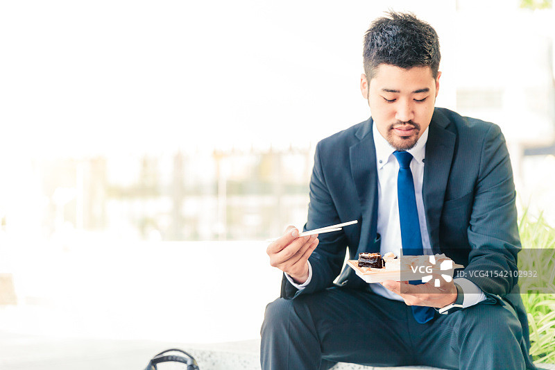 商人户外吃寿司图片素材