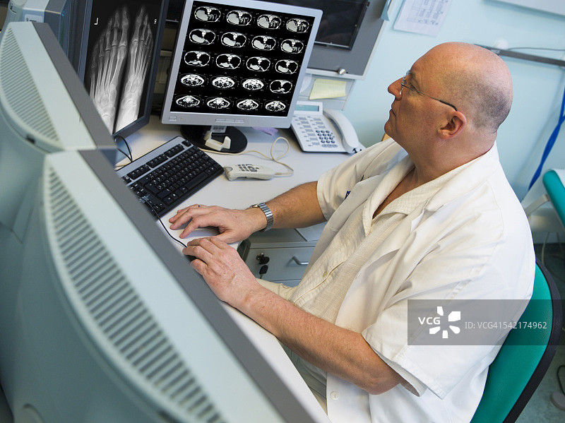 肿瘤研究所的资深放射科医生正在检查核磁共振扫描图片素材