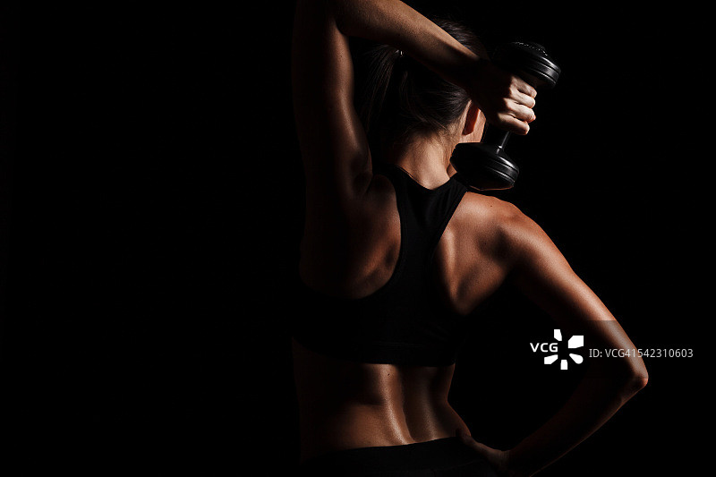 女性使用哑铃锻炼的罕见视角图片素材