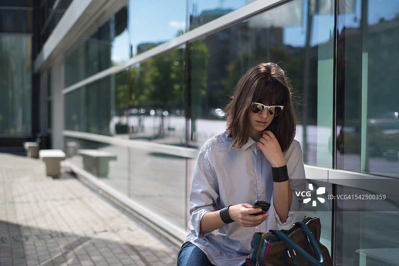 在保加利亚索非亚街头看手机的女人图片素材