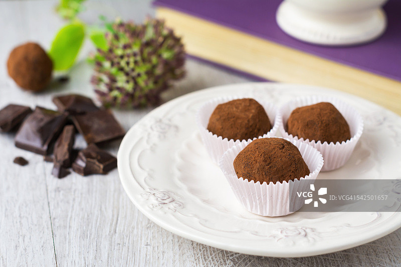 白色盘子上的三个巧克力松露图片素材