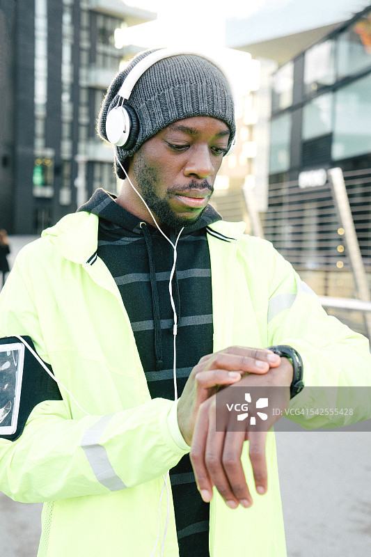 正在看智能手表的运动男人图片素材