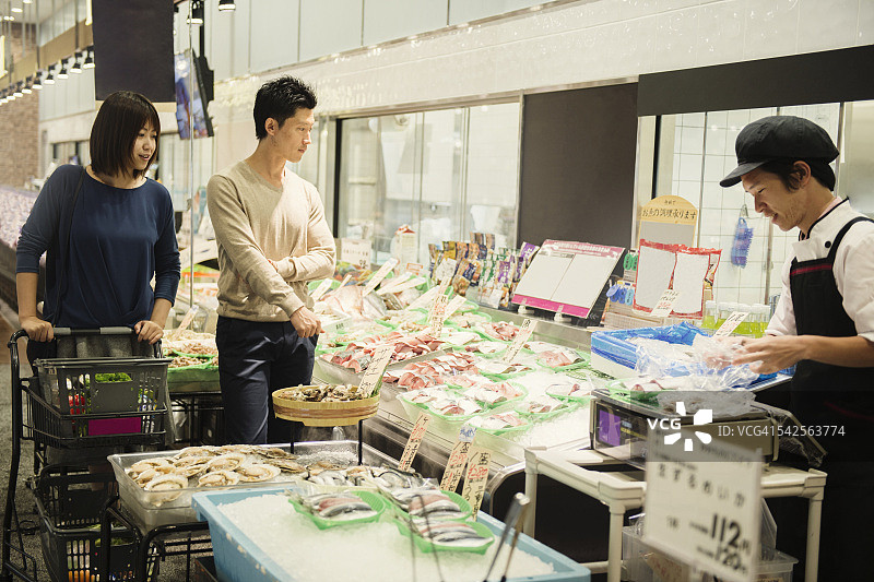 在鱼店工作的年轻男人图片素材