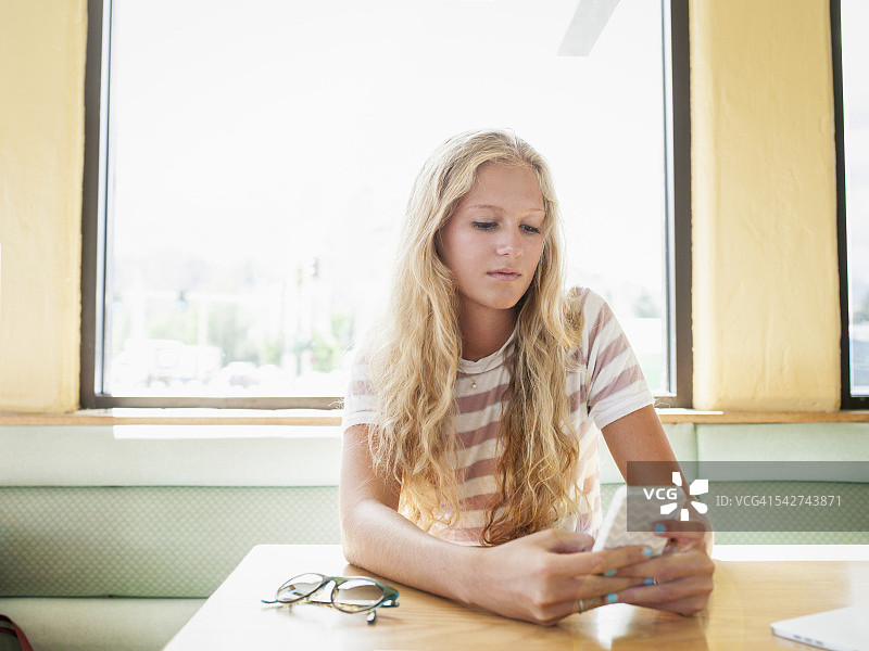 在咖啡馆使用手机的少女图片素材