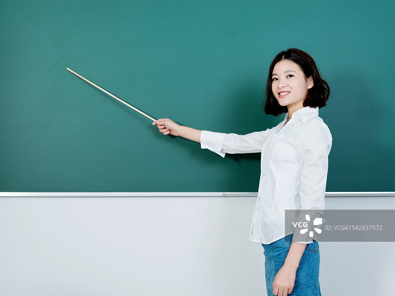 年轻女教师指向黑板图片素材
