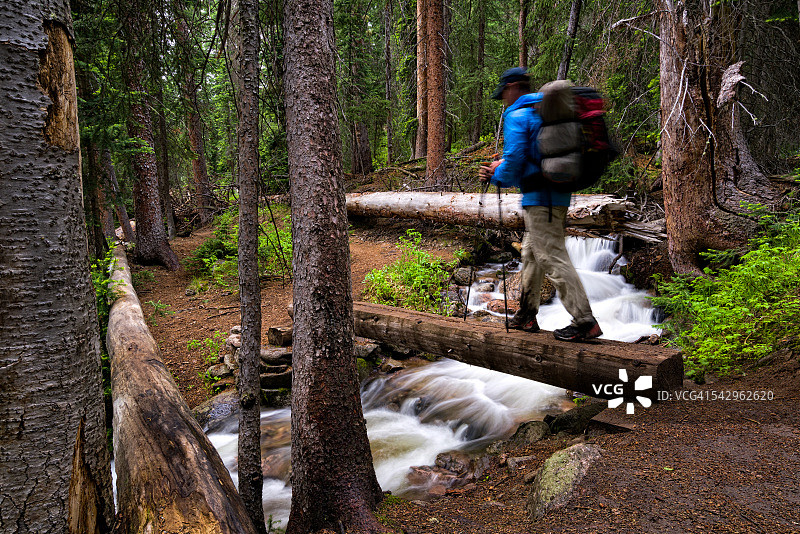 徒步者穿过山涧上的桥梁图片素材