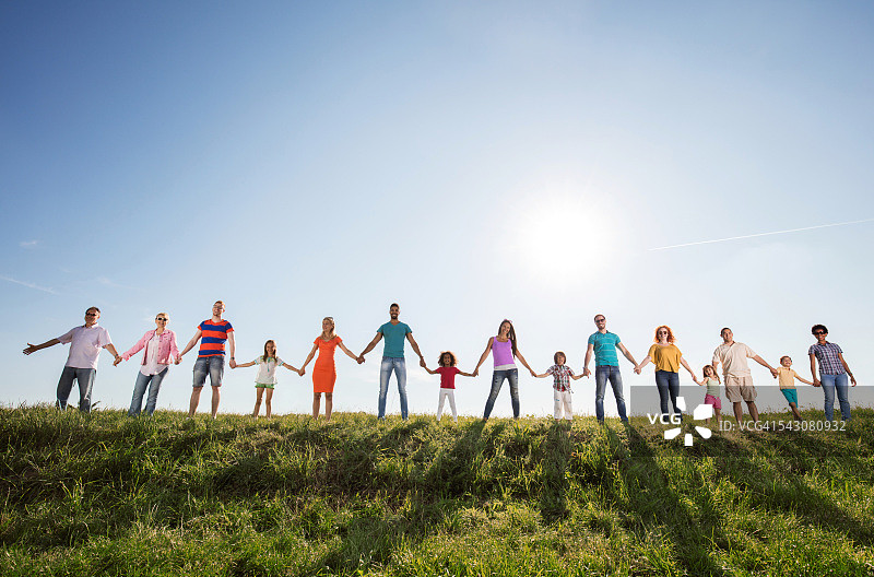 一大群快乐的人手牵着手对着天空图片素材