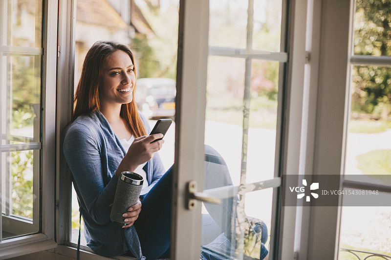 享受乡村清新空气，品味咖啡，使用智能手机图片素材