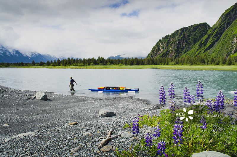 男子在阿拉斯加州将皮划艇和装备拖到支流到熊湖和熊冰川图片素材