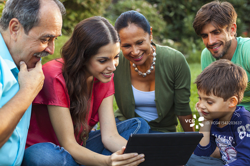 三代同堂在花园里使用平板电脑图片素材