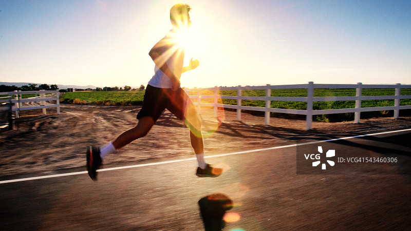 在乡村道路上慢跑的20多岁运动型男子图片素材