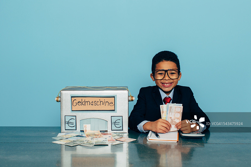 德国商务男孩用赚钱机赚欧元图片素材