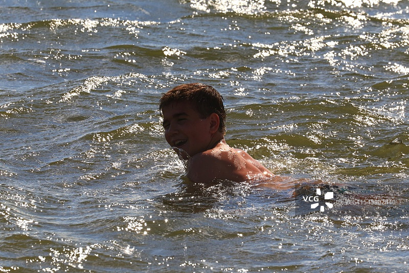 年轻男人在波涛汹涌的水中沐浴图片素材