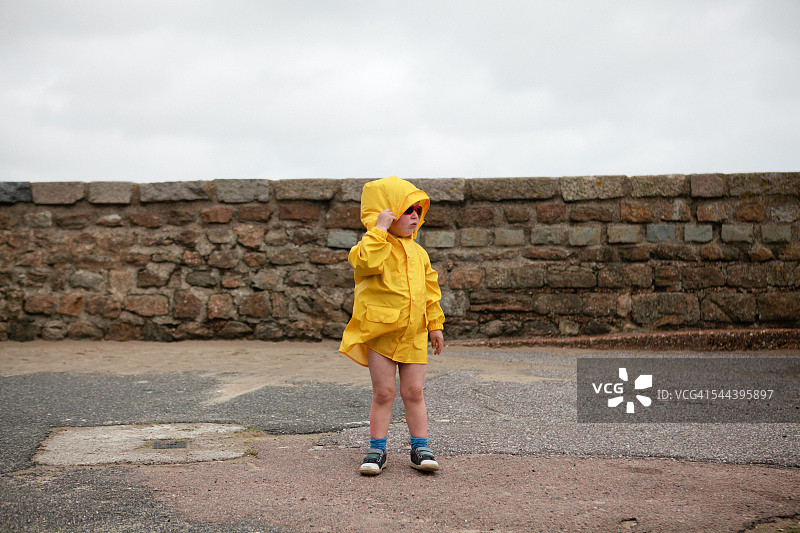 在海滩上穿着黄色外套的小男孩图片素材