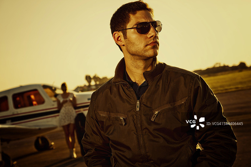 年轻情侣站在螺旋桨飞机前图片素材