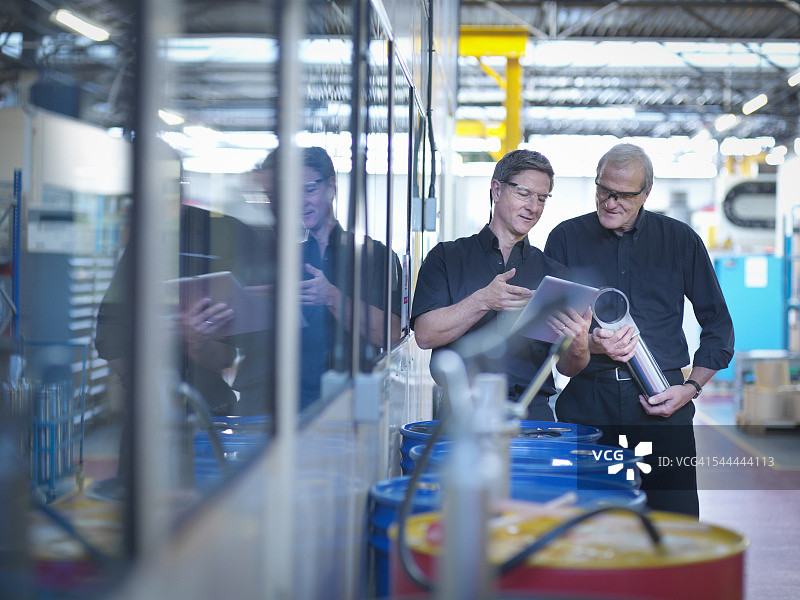 工程师设计师在工厂讨论数字平板电脑上的计划图片素材
