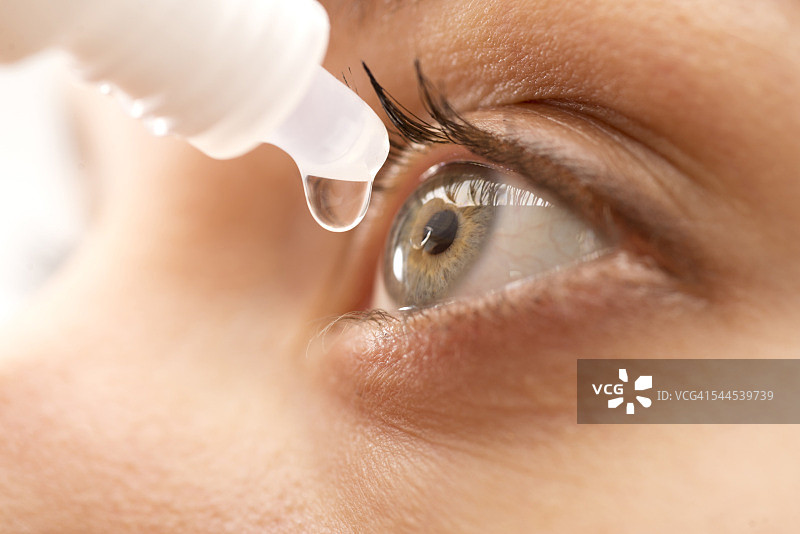年轻女人使用滴眼液，特写镜头图片素材