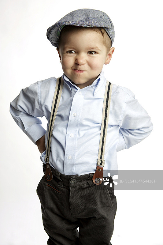 戴帽子和背带裤的小男孩撅着嘴图片素材