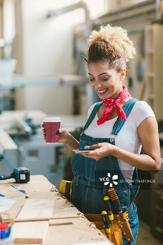 在工作室发短信的拉丁裔木匠图片素材