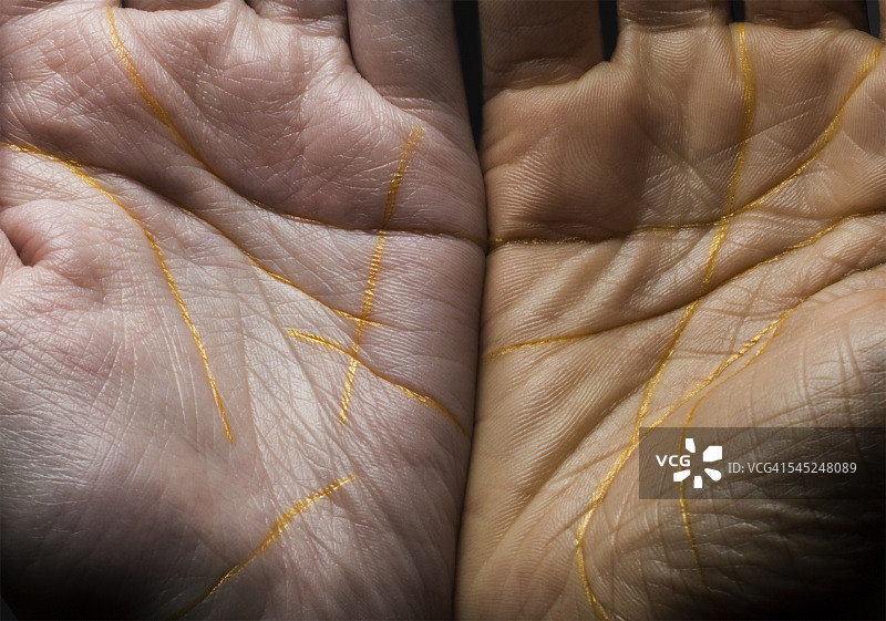 特写：双手用金线勾勒轮廓图片素材