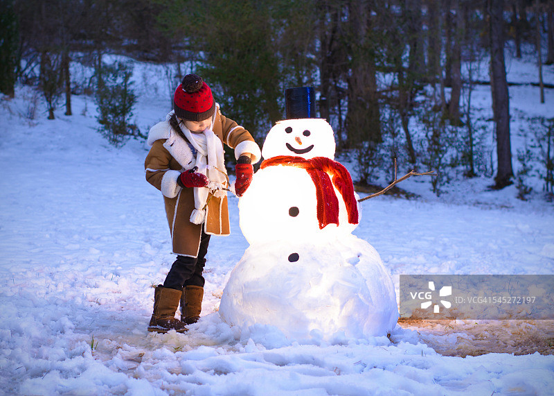 小女孩在堆雪人图片素材