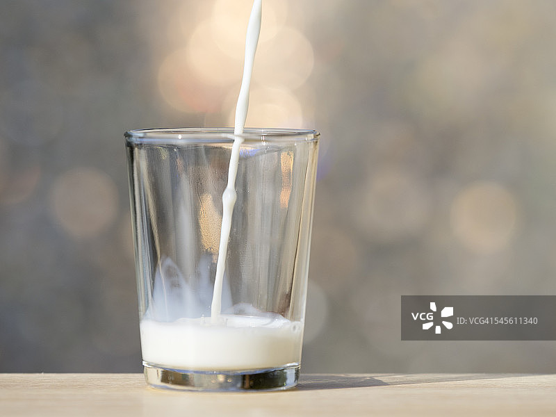 在玻璃杯中倒入牛奶图片素材
