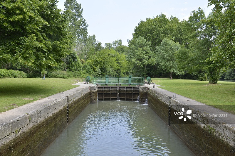 两片草地之间的水闸图片素材